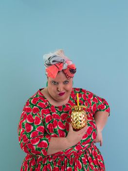 Overweight plus size female, fat women, Fat girl, Chubby, holding golden fruit ananas isolated on cyan background - lifestyle Woman diet weight loss overweight problem concept. High quality photo