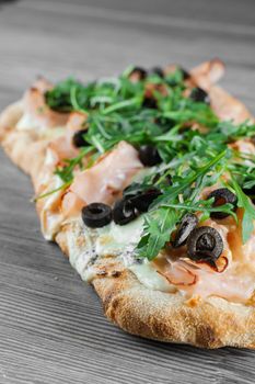 Pinsa romana gourmet italian cuisine. Scrocchiarella. Food delivery. Pinsa with meat, arugula, olives