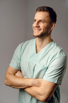 Surgeon weared in medical robe smile and posing on white background. Handsome happy doctor posing in studio