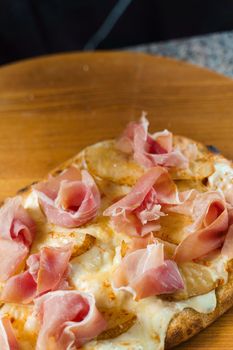 Chef cooking pinsa romana with pear, cheese, prosciutto in delivery box. Scrocchiarella gourmet italian cuisine