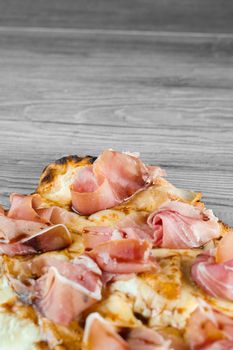 Scrocchiarella with pear, cheese, prosciutto on grey wooden background. Pinsa romana gourmet italian cuisine. Junk food.