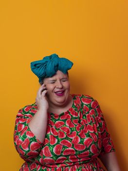 Trendy plus size woman having conversation talking by smartphone over yellow background smiling with an idea or question pointing finger with happy face, number one. High quality photo