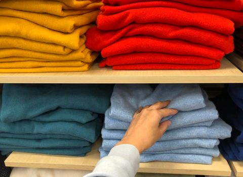 Rows of folded colorful clothes in a shop