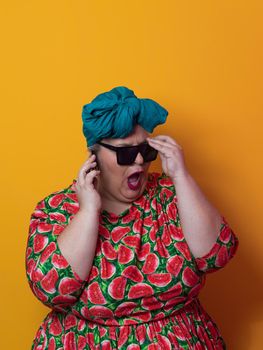 Trendy plus size woman having conversation talking by smartphone over yellow background smiling with an idea or question pointing finger with happy face, number one. High quality photo