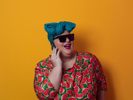 Trendy plus size woman having conversation talking by smartphone over yellow background smiling with an idea or question pointing finger with happy face, number one. High quality photo