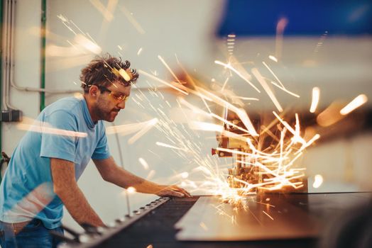 Within heavy industry. A man works in a modern factory on a CNC machine. Selective focus. High-quality photo