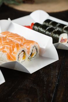 Philadelphia roll on the food delivery plate. Roll with salmon, shrimp and mango