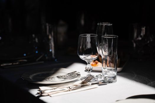 Glasses, plate and cutlery on the table. Table setting in the restaurant