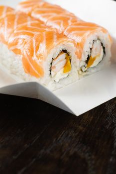 Philadelphia roll on the food delivery plate. Roll with salmon, shrimp and mango