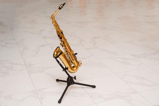 Saxophone musician instrument on stand on white background. Sax musical instrument for play jazz