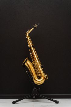 Sax musical instrument for play jazz. Saxophone musician instrument on stand on black background