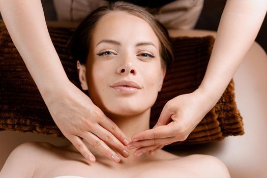 Masseur is making facial massage in spa for model with perfect skin. Beauty procedure