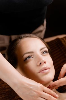 Masseur is making facial massage in spa for model with perfect skin. Beauty procedure