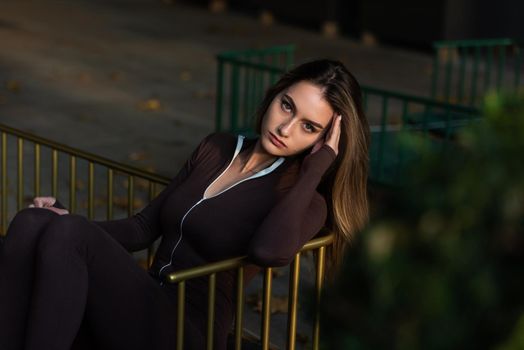 Portrait of a fashionable young brunette woman wearing solid long sleeve bodycon one piece jumpsuits.