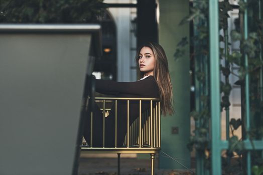 Portrait of a fashionable young brunette woman wearing solid long sleeve bodycon one piece jumpsuits.