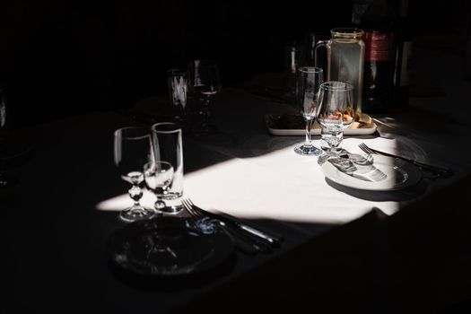 Glasses, plate and cutlery on the table. Table setting in the restaurant