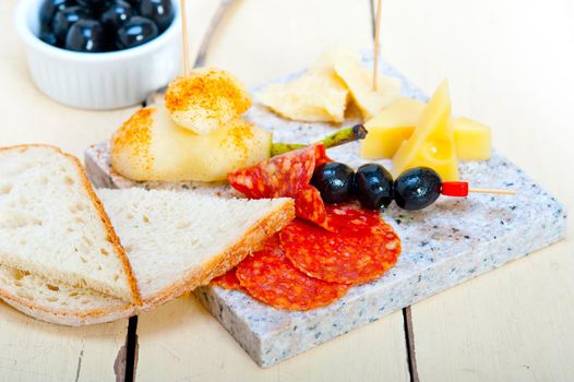 cold cut assortment cheese salami and fresh pears served on a granite stone