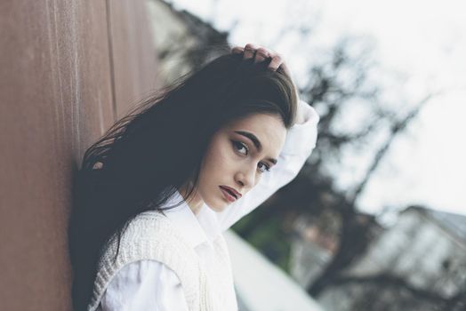 Outdoor portrait of a young beautiful fashionable lady wearing stylish coat . Model looking aside. Female fashion concept. City lifestyle. Close up. big plump lips