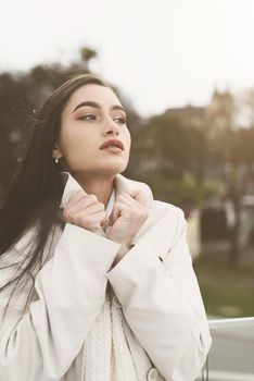 Outdoor portrait of a young beautiful fashionable lady wearing stylish coat . Model looking aside. Female fashion concept. City lifestyle. Close up. big plump lips