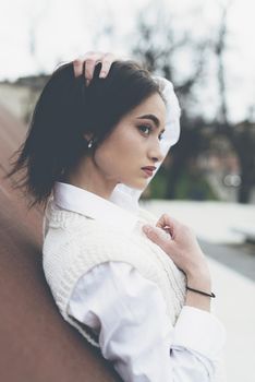 Outdoor portrait of a young beautiful fashionable lady wearing stylish coat . Model looking aside. Female fashion concept. City lifestyle. Close up. big plump lips