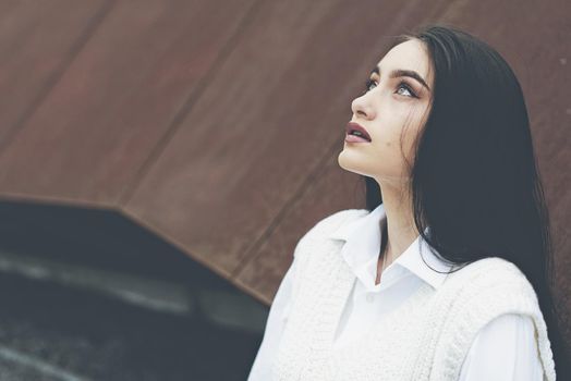 Outdoor portrait of a young beautiful fashionable lady wearing stylish coat . Model looking aside. Female fashion concept. City lifestyle. Close up. big plump lips