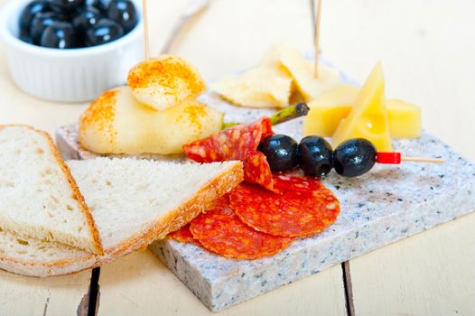 cold cut assortment cheese salami and fresh pears served on a granite stone