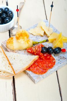 cold cut assortment cheese salami and fresh pears served on a granite stone