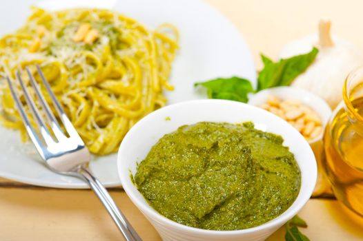 Italian traditional basil pesto pasta ingredients parmesan cheese pine nuts extra virgin olive oil garlic on a rustic table 