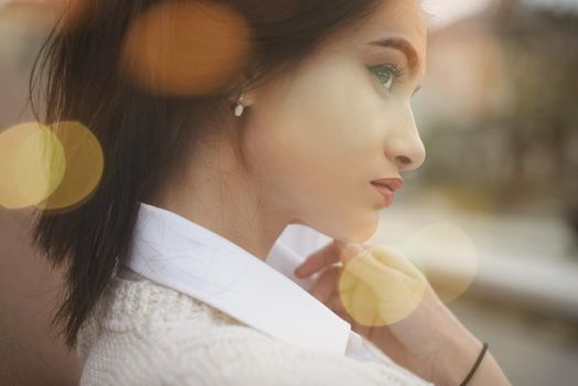 Outdoor portrait of a young beautiful fashionable lady wearing stylish coat . Model looking aside. Female fashion concept. City lifestyle. Close up. big plump lips