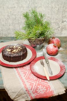 Still life with chocolate cake, Christmas tree and pomegranate. Rustic style. From the series Baking for Holidays