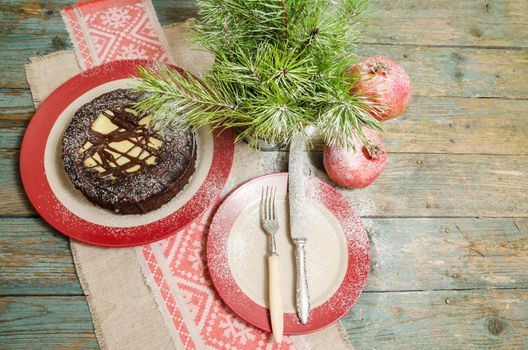 Still life with chocolate cake, Christmas tree and pomegranate. Rustic style. From the series Baking for Holidays