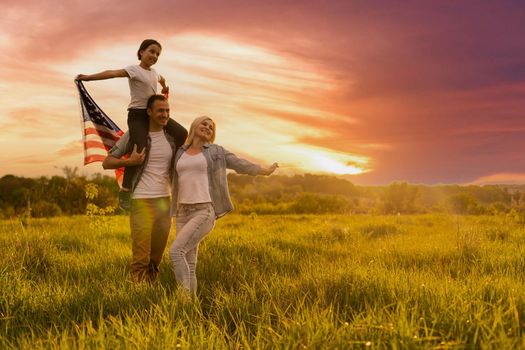 Happy family in wheat field with USA american flag on back