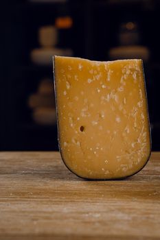 Parmesan hard aged cheese on wooden background. Snack tasty piece of cheese for appetizer