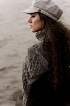 Attractive girl tourist travels around her country. Young woman with curly hair looks at the lake and dreams about her life