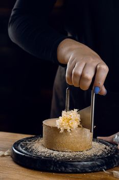 Shaving tete de moine cheese using girolle knife. Monks head. Variety of Swiss semi-hard cheese made from cows milk.