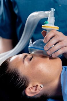 The doctor puts on a mask for artificial ventilation of the lungs in the intensive care unit.