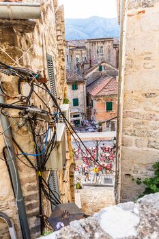 KOTOR, MONTENEGRO - September 16, 2019: Tangled wires and cables between old houses in Kotor city in Montenegro