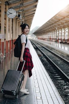 Summer, Travel, Vacation, Relax, A smiling female tourist looks at the train station for a summer vacation, travel concept.