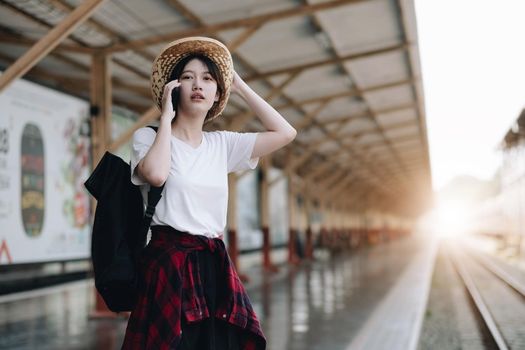 Young traveler woman looking for friend planning trip at train station. Summer and travel lifestyle concept.