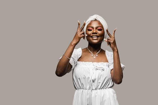 Black muslim woman holding up 2 fingers have party. African girl is celebrating her birthday and having fun.