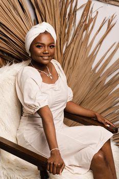 Portrait of black business lady on the dry leaves background. African model is posing in studio