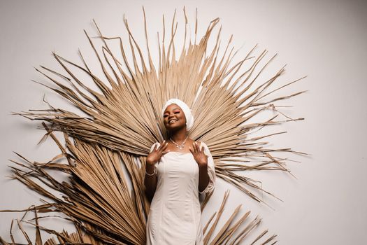 Portrait of black business lady on the dry leaves background. African model is posing in studio