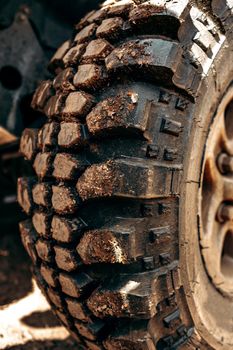 Wheel of offroad car in a muddy roadn forest close up