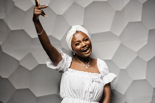 Black muslim woman is putting her hands up and dance and party. African girl is celebrating her birthday and having fun