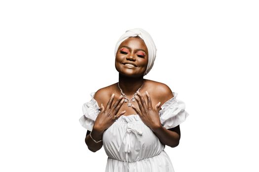 Beauty portrait of black muslim woman weared white dress and headscarf on white background. Softness and wellness of body and skin