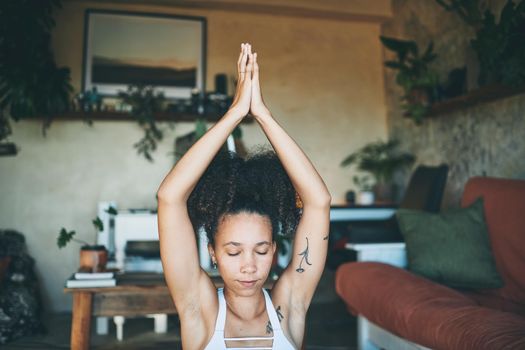 Shot of a sporty young woman meditating at home - Stock Photo