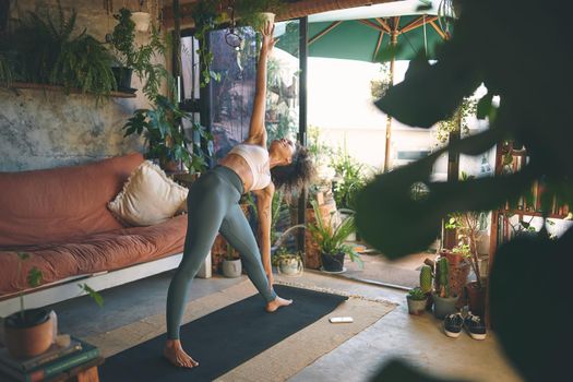 Shot of a young woman doing yoga in her living room