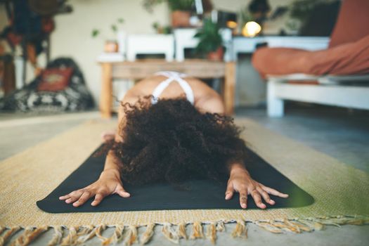 Cropped shot of a woman stretching on her yoga mat