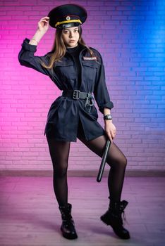 woman in a Russian police uniform with a baton. English translation Police