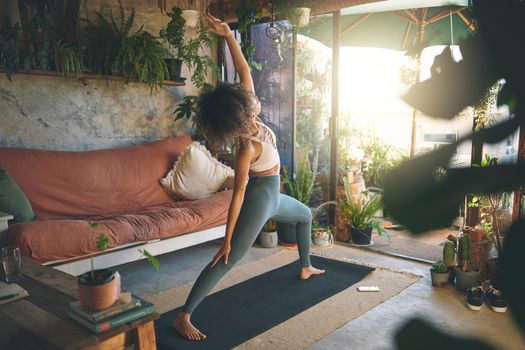 Shot of a young woman doing yoga in her living room